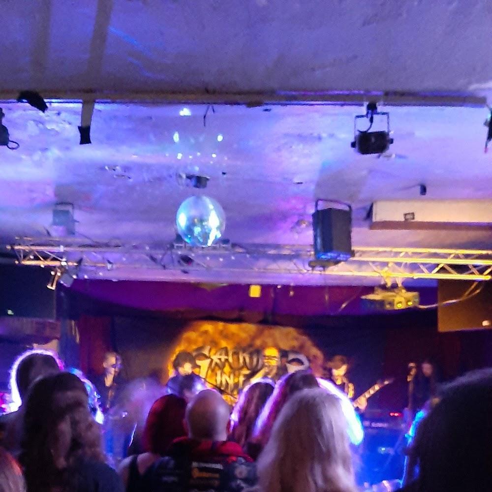 A crowded concert venue with a disco ball.